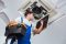 HVAC technician inspecting air conditioning unit, emphasizing maintenance and repair services for optimal indoor comfort.